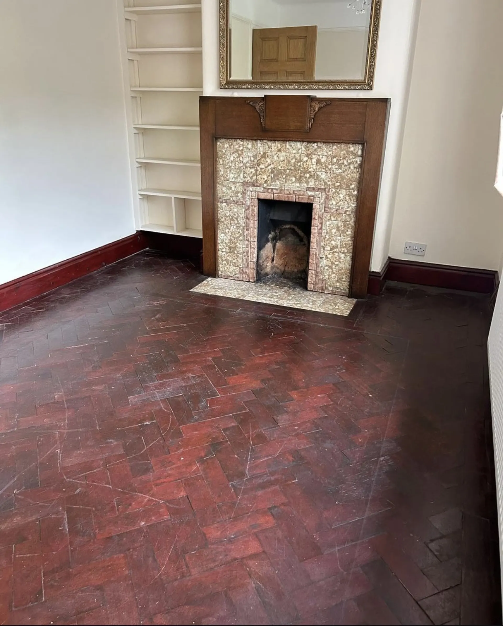 Parquet en chevrons devant une cheminée, avant rénovation